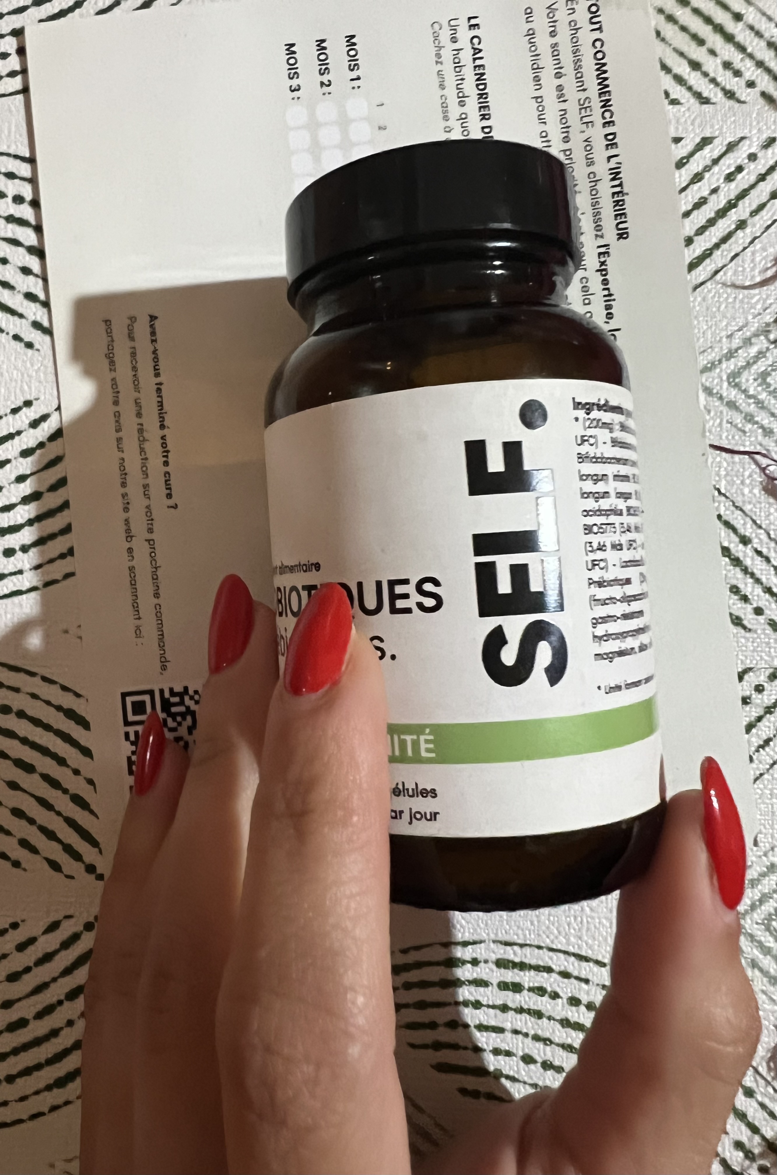 Une cliente SELF tient son flacon de probiotiques